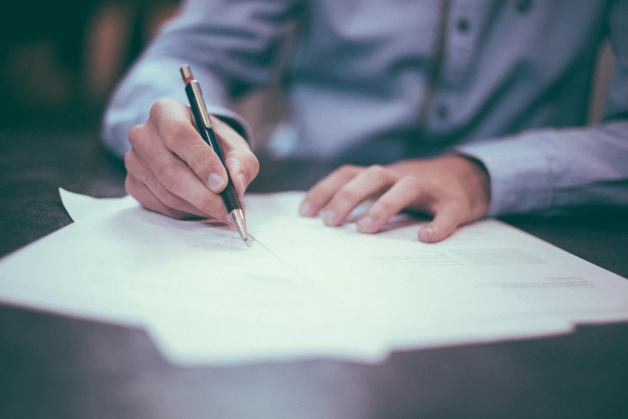 A man signing a document with a pen