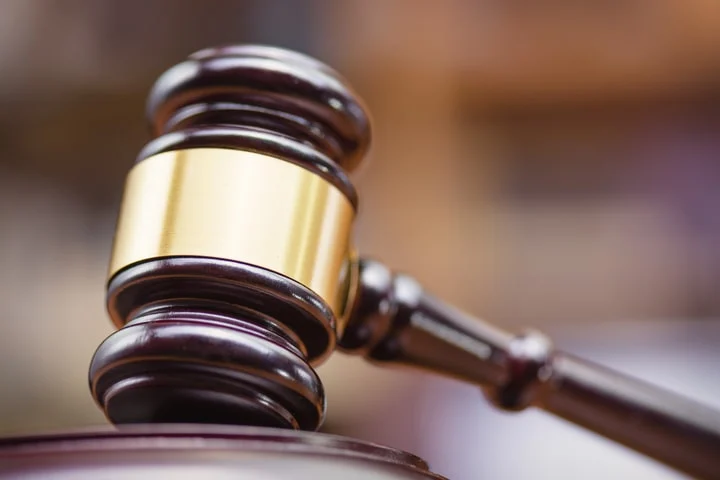 Close-up of a wooden gavel with a brass band
