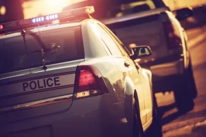 Police cars parked on a street at sunset