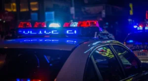 A police car with flashing red and blue lights at night